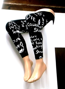 image of bottom half of mannequin wearing leggings with painting text sitting on top wall