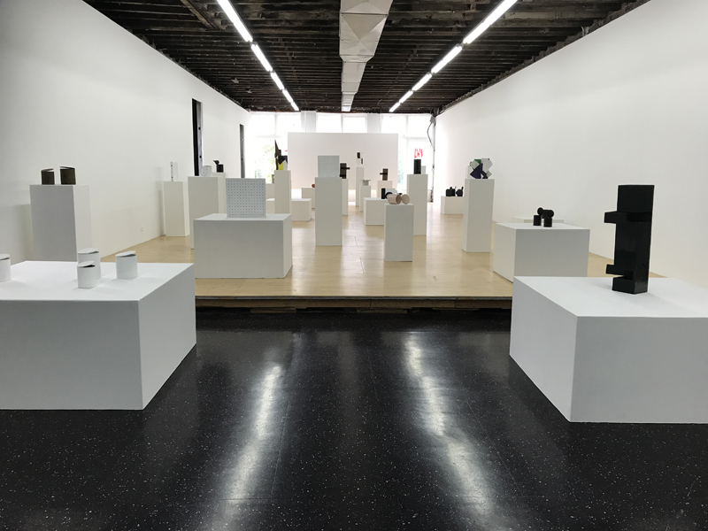 installation view of cans and boxes on pedestals