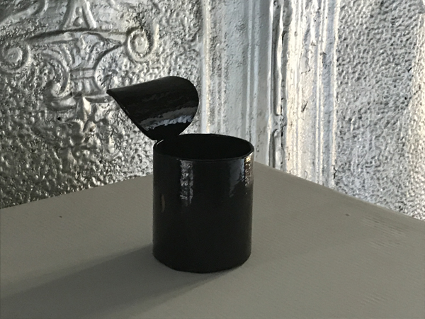 small black can with curvy lid on pedestal