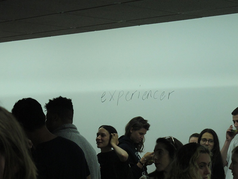 the word experiencer written on the wall seen behind the heads of people